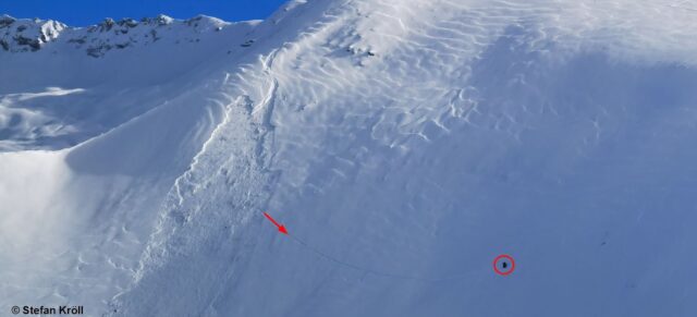 Lawinenabgang Filzenkogel in den Nördlichen Zillertaler Alpen. Oben erkennt man die Einfahrtsspur. Der Pfeil zeigt die Ausfahrtsspur, der Kreis die Person, die aus der Lawine ausfahren konnte (Foto: 23.01.2022)