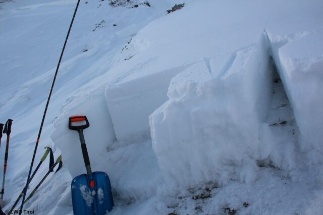 Profil, welches bei der oben abgebildeten Lawine im Rettenbachtal aufgenommen wurde. Oberer Teil der Schneedecke in "hellerem weiß". Unterer Teil der Schneedecke in "mattere weiß". Unten ist diese massiv aufbauend umgewandelt ("Schwimmschneenest"). Dort, wo diese Schicht noch von einem ausreichenden "Brett" überlagert ist, könnte ein Bruch initiiert werden. (Foto: 25.02.2022) Profil, welches bei der oben abgebildeten Lawine im Rettenbachtal aufgenommen wurde. Oberer Teil der Schneedecke in "hellerem weiß". Unterer Teil der Schneedecke in "mattere weiß". Unten ist diese massiv aufbauend umgewandelt ("Schwimmschneenest"). Dort, wo diese Schicht noch von einem ausreichenden "Brett" überlagert ist, könnte ein Bruch initiiert werden. (Foto: 25.02.2022)