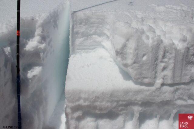 Typisches Bild eines Schneeprofils: Zuoberst: Schneeauflage ab 25.03. Die glatte Fläche darunter zeigt eine unvollständige Bruchfläche einer dünnen kantigen Schicht auf einem (in diesem Fall gut ausgeprägten) Schmelzharschdeckel. Darunter erkennt man gefrorene Wasserkanäle vom Warmwetter vor dem 25.03.2023