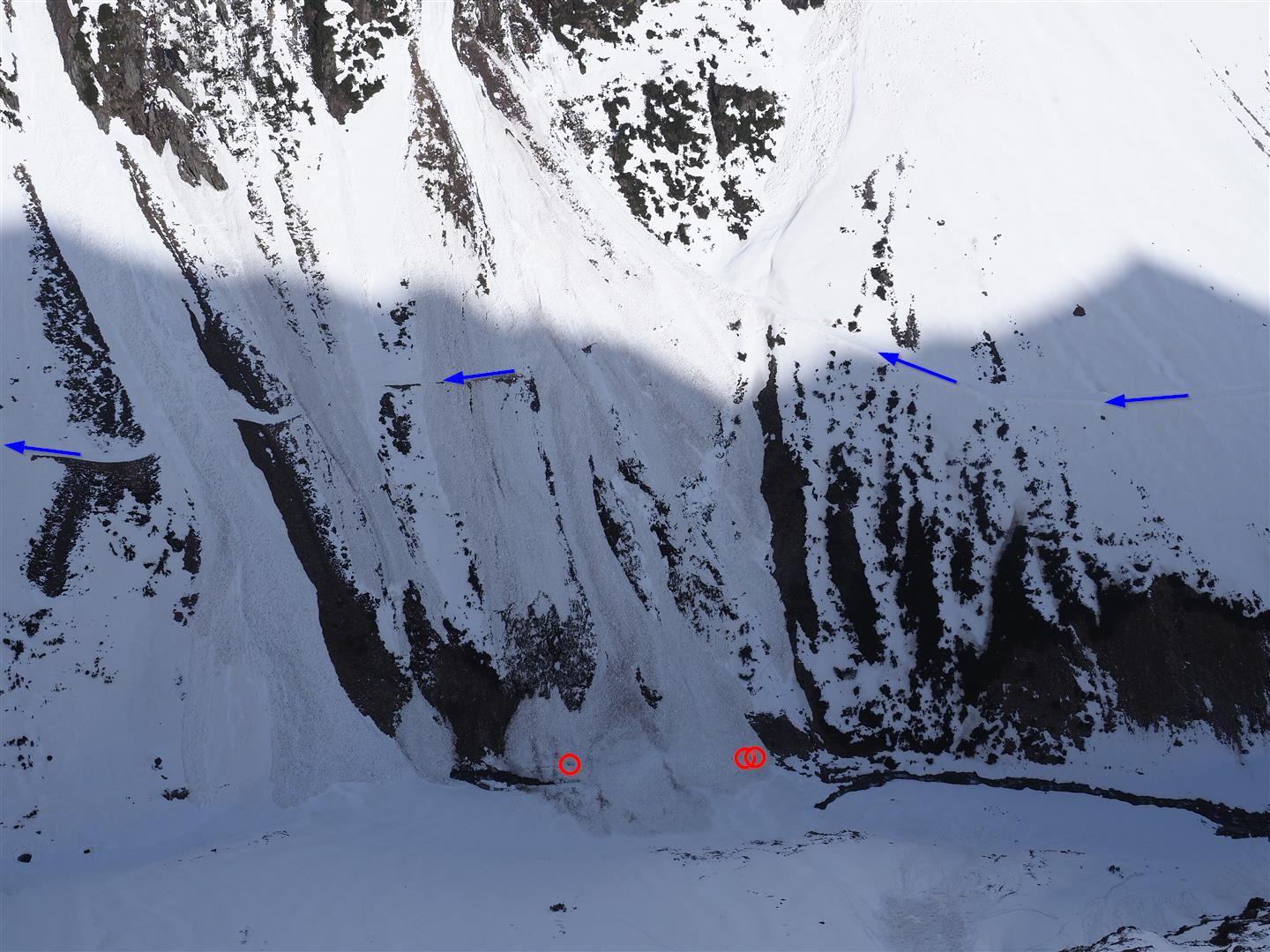 Unterer Teil der Lawinenstutzbahn samt Ablagerungsbereich. Bei den roten Kreisen wurden Personen ausgegraben. Die blauen Pfeile markieren den Hüttenzustieg (Foto: 12.04.2024; © LWD Tirol)