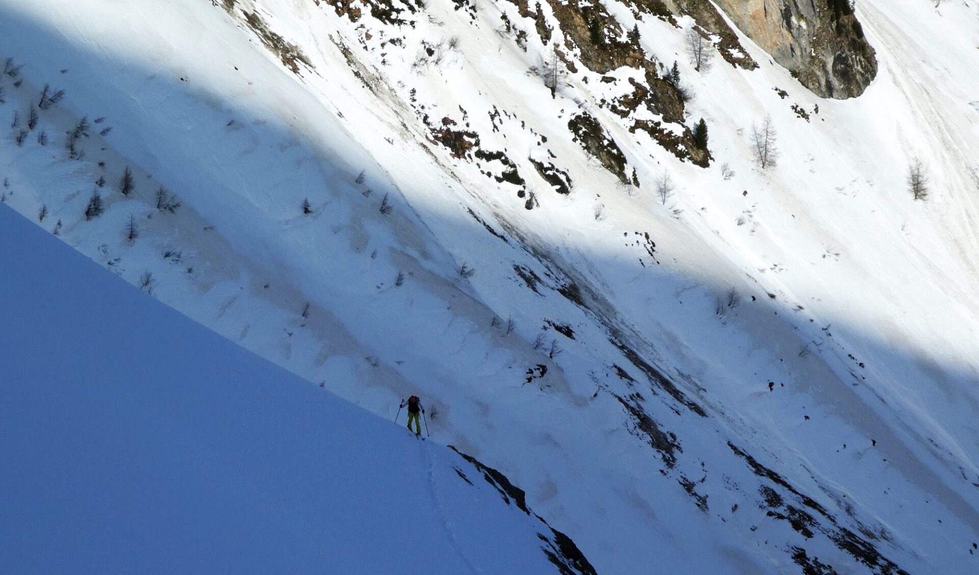 Die Rücken im Hintergrund des Skitourengehers sind abgeblasen. Zum Vorschein kommt der Saharastaub, welcher dort am 09.04. mit Niederschlag abgelagert wurde. Kleiner Kaserer (Foto: 12.04.2024, ©Barbara Fink).