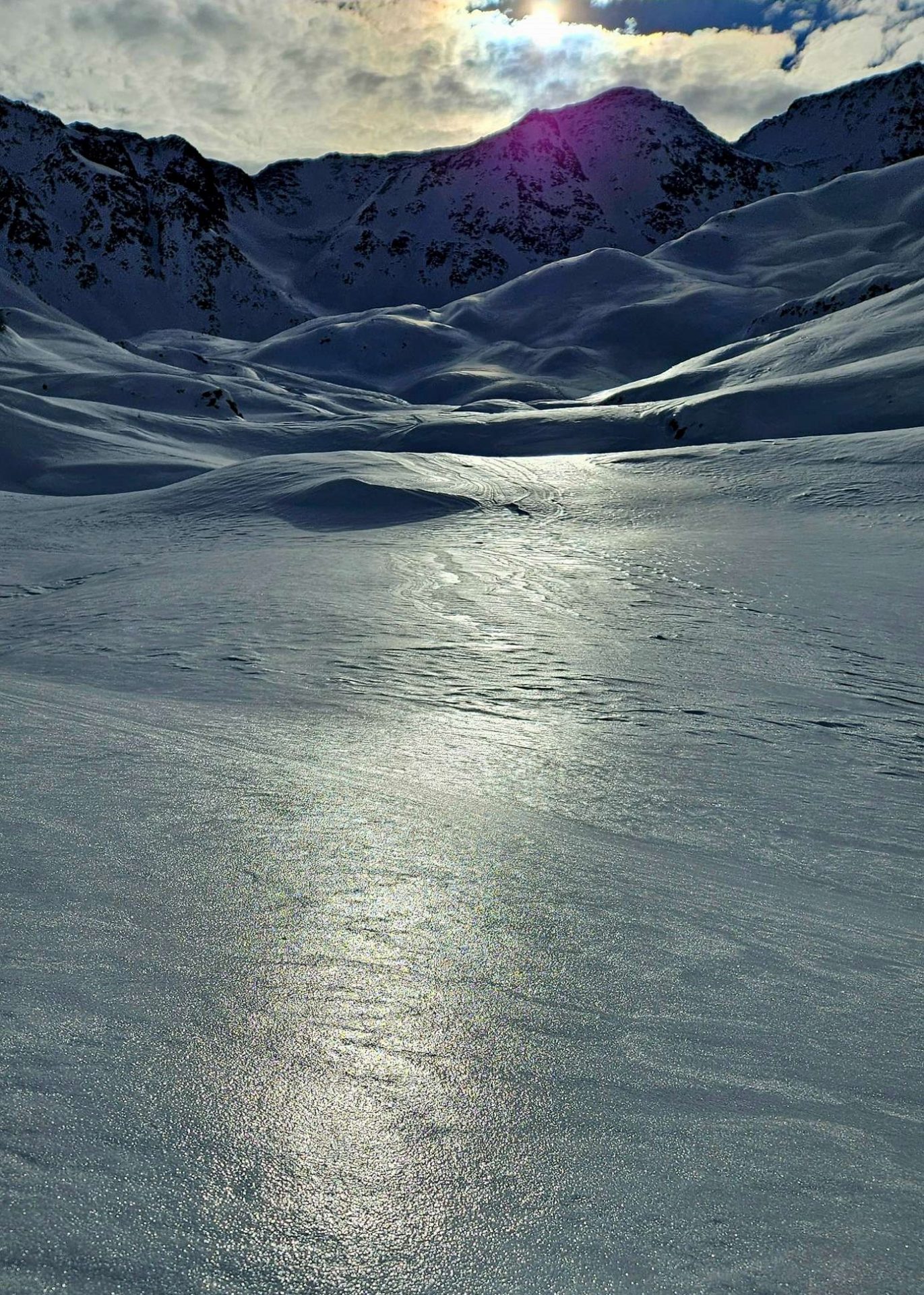 Durch gefrierenden Regen entstand am 24. Dezember vielerorts bis hoch hinauf eine dünne Eislamelle an der Schneeoberfläche. Ursächlich dafür war das Eintreffen einer Warmfront. Hierbei glitten feuchtwarme Luftmassen auf einer kalten, bodennahen Luftschicht auf. In weiterer Folge fielen Regentropfen durch die kältere bodennahe Schicht hindurch und kühlten dabei stark ab. Als die unterkühlten Tropfen dann auf der Schneeoberfläche auftrafen, gefroren diese dort sofort an und bildeten eine dünne, glasige Eislamelle. Hier im Bereich des Staller Sattels in den Deferegger Alpen. (Foto: 26.12.2023) © Daniel Kleinlercher.