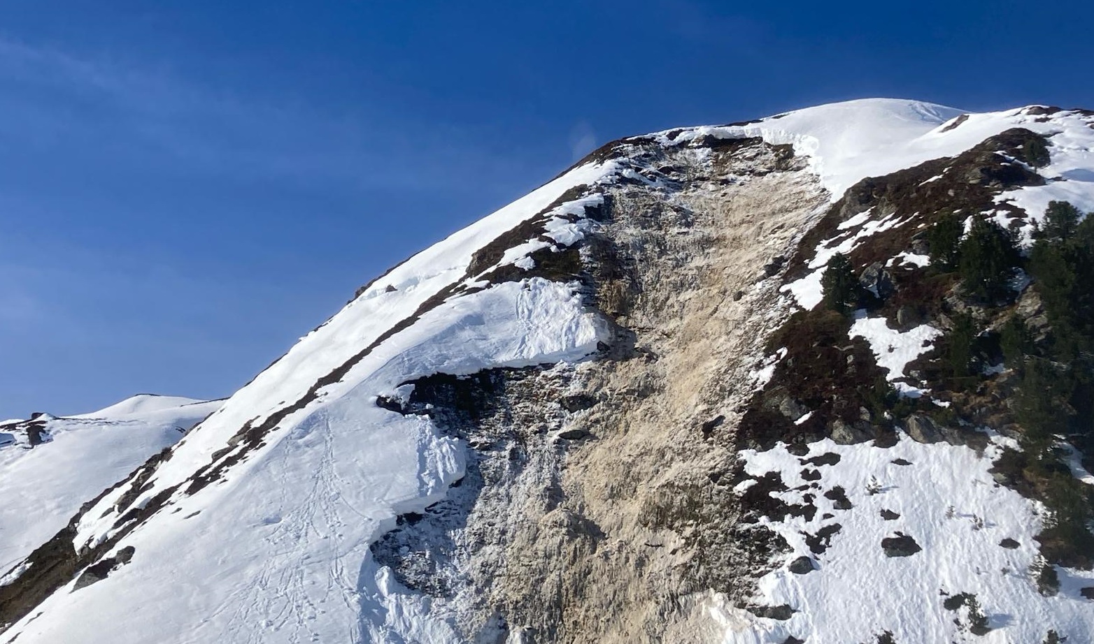 Anrissbereich der spontanen Gleitschneelawine im Bereich der Pfundsalm an einem Südosthang auf rund 2100 m (Foto: 18.02.2024) © Alpinpolizei.