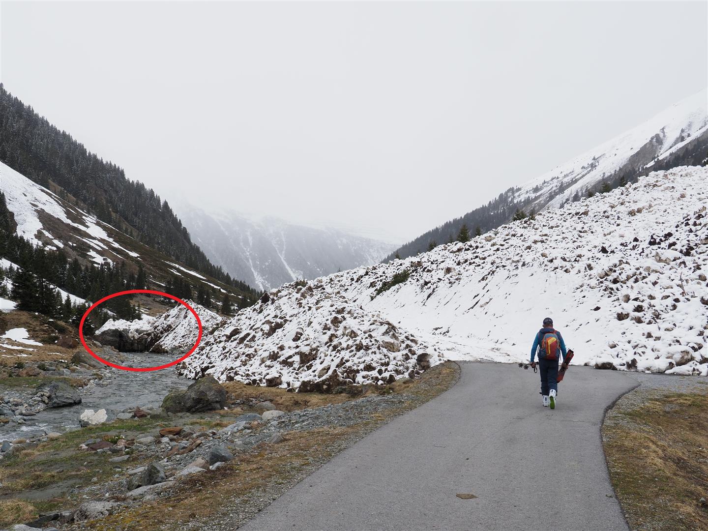 Im Bild noch einmal die mächtige Lawinenablagerung vom 15. April im Jamtal. Rot eingekreist ist ein riesiger Felsblock, der von der Lawine ins Tal transportiert wurde und im Flussbett zu liegen kam. (Foto: 19.04.2024) © LWD Tirol.