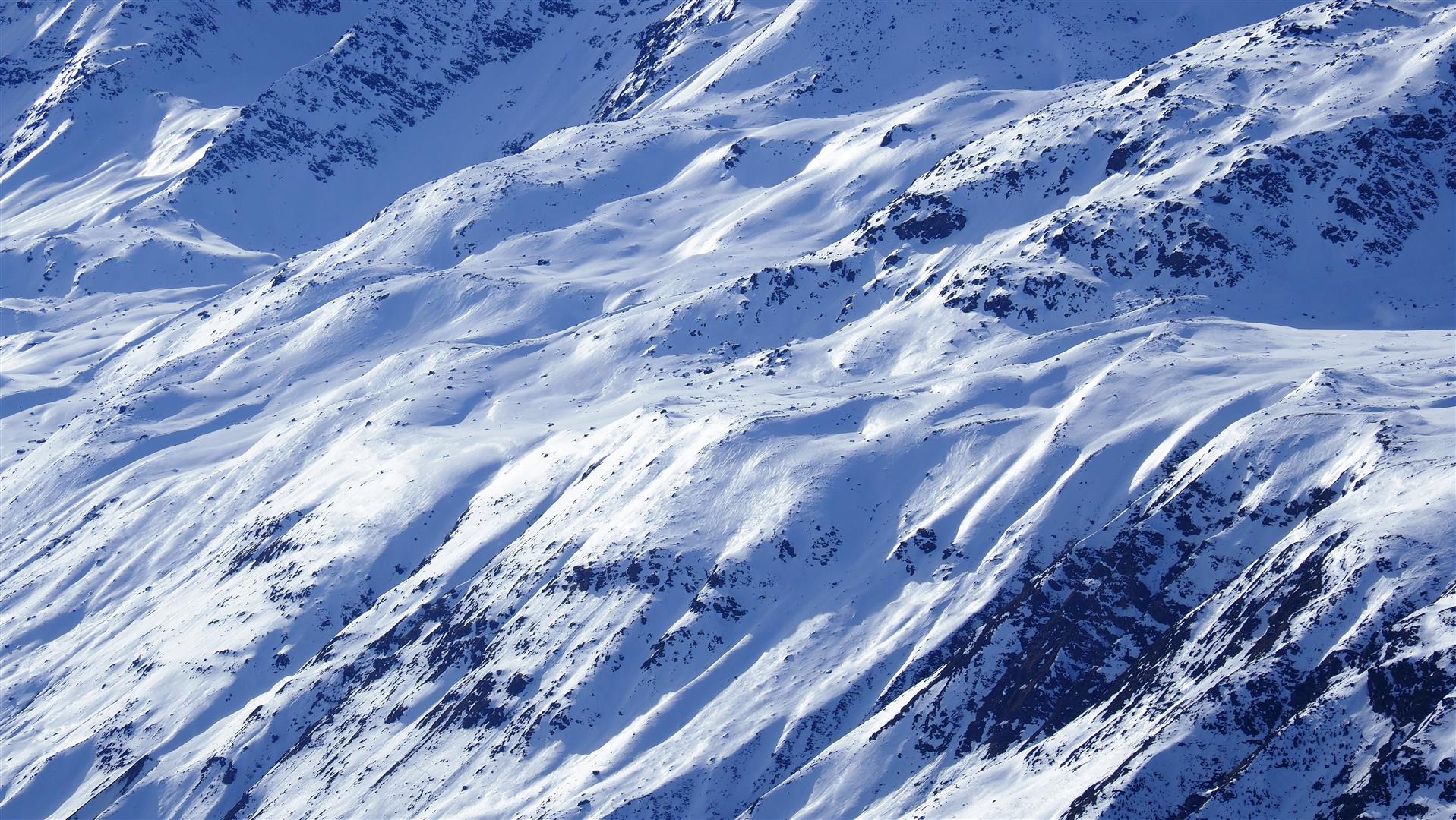 Die glänzende Schneeoberfläche bezeichnet man als "Firnspiegel". Dieser hat nichts mit guten "Firnverhältnissen" zu tun. Die Schneedecke wurde dort durch Strahlungs- und Wärmeeinfluss oberflächig feucht und anschließend durch etwas Windeinfluss oberflächig gefroren. An der Schneeoberfläche befindet sich dort somit eine dünne Eislamelle. Gurgler Gruppe (© LWD Tirol, 22.02.2025)