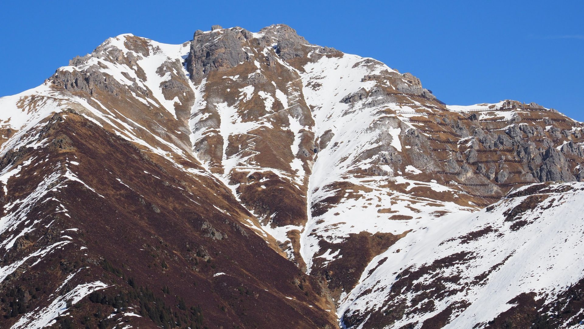 Hochdruckwetter und trockene Luft sorgt dafür, dass die Ausaperung sehr stark von der Sonneneinstrahlung und somit von Hangausrichtung und Hangsteilheit abhängt. Entsprechend markant zeigen sich auch die Ausaperungsmuster (©LWD Tirol, 06.03.2025). 