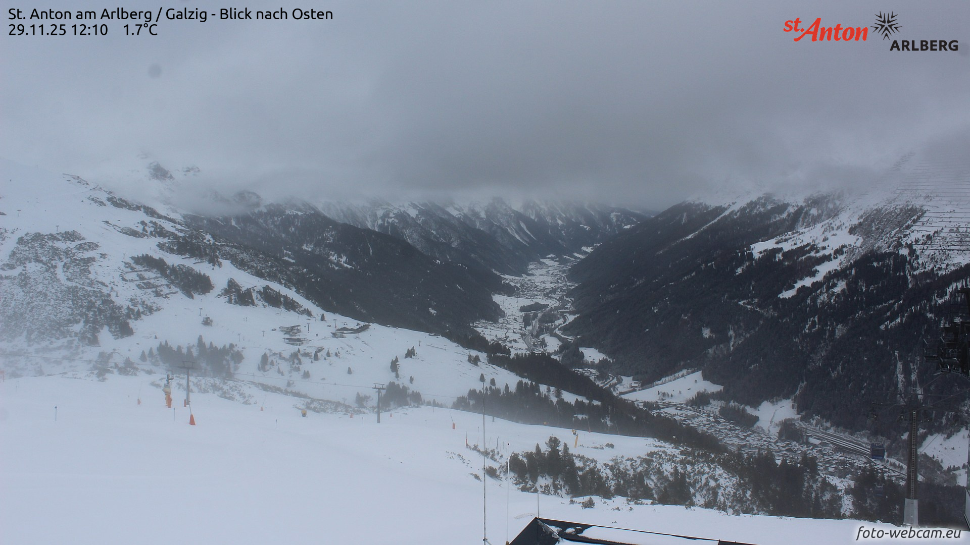 Webcam-Bild vom 29.11. vom Arlberggebiet. Aus den Wolken nieselte es gebietsweise etwas heraus. Am Nachmittag des 29.11. klarte es dann auf. In Folge bildete sich eine dünne Schmelzkruste an der Schneeoberfläche. (© foto-webcam.eu)